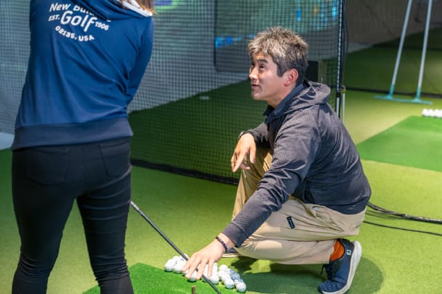 ゴルフレッスンを受けている女性の様子